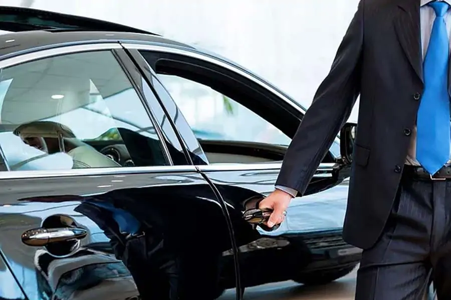 Chauffeur opening the door of a luxury Mercedes vehicle